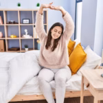 young-beautiful-hispanic-woman-waking-up-stretching-arms-bedroom_839833-30945
